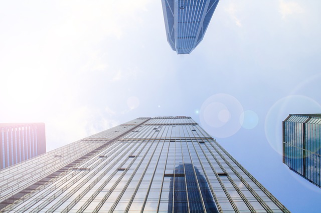 Looking up at a glass high-rise tower in bright sunlight