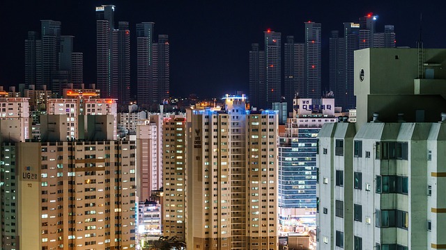 Lit high-rise apartment towers in a city skyline at night