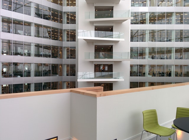 Interior atrium of an office building with glass-walled floors and seating below