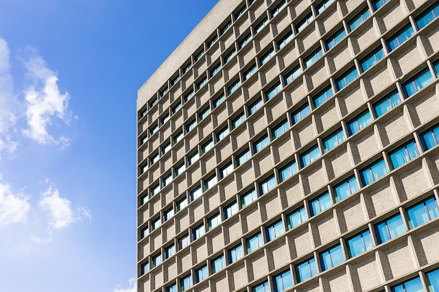 Corner of a concrete apartment building with a grid of recessed windows
